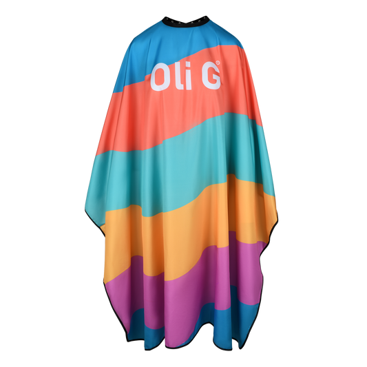 A professional cutting cape with colorful geometric pattern, featuring the brand logo 'Oli G' prominently displayed.